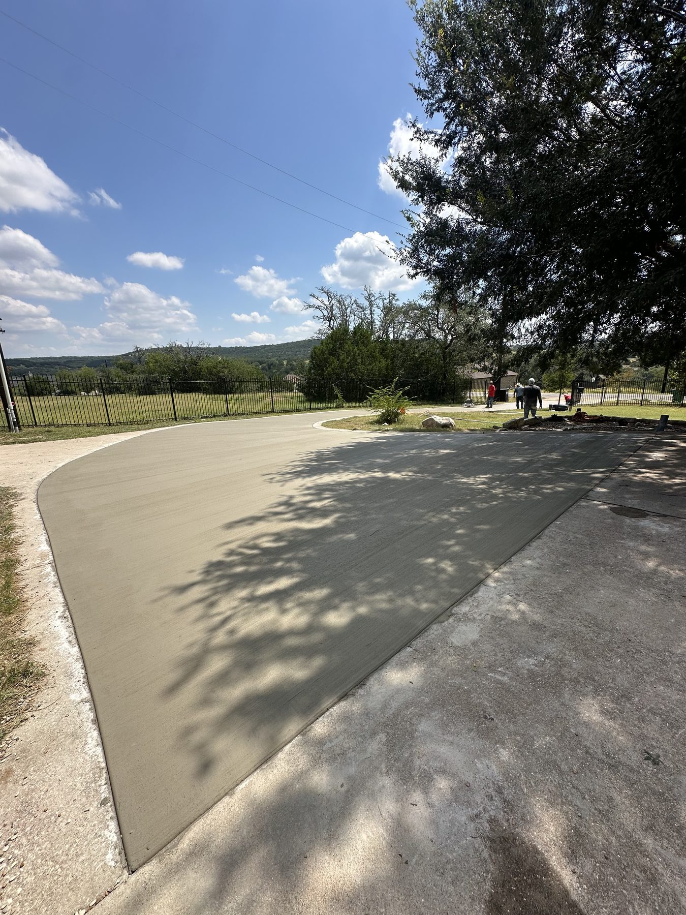 Curved new concrete driveway through a wooded lot