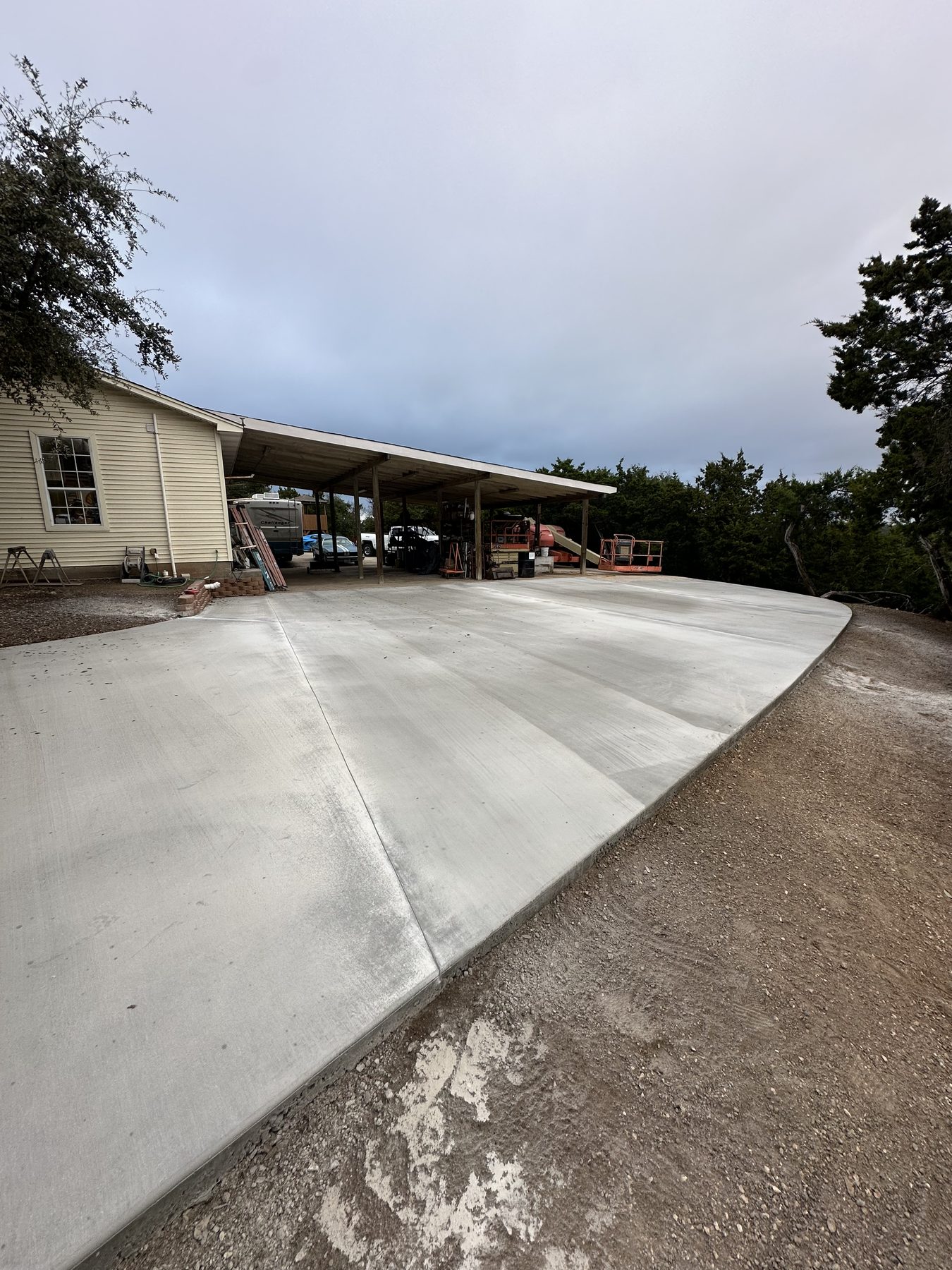 New concrete driveway leading to a ranch home