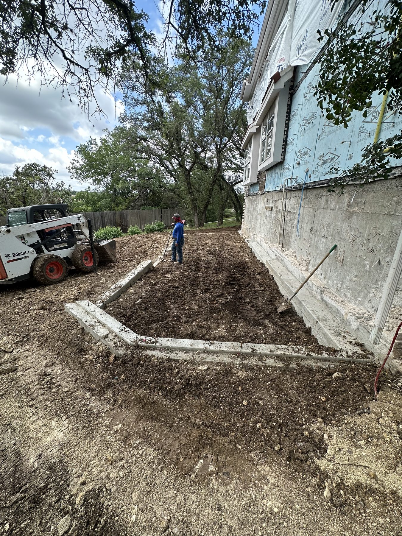 Skid steer backfilling a new footing