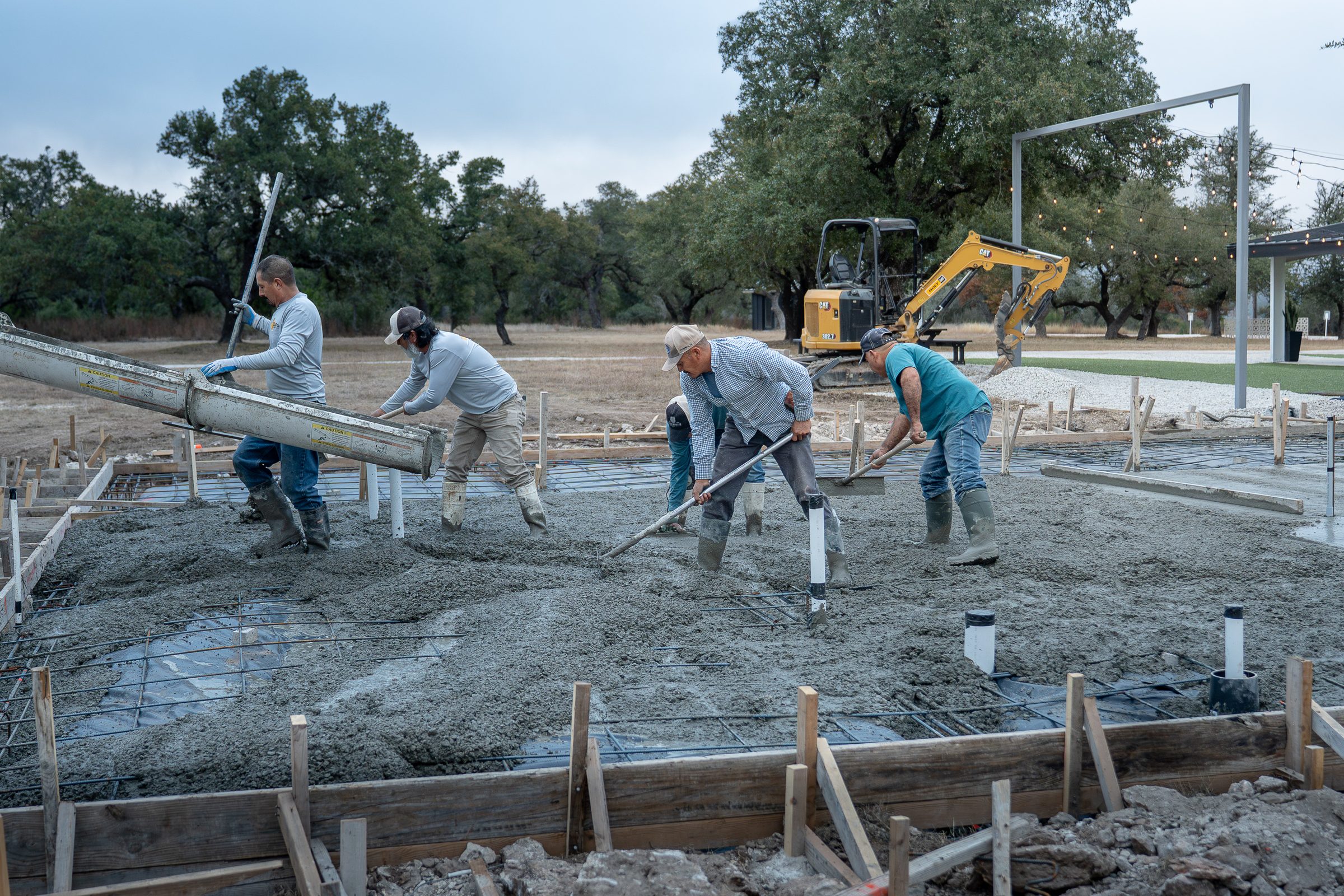 Pulling a screed board across a fresh pour
