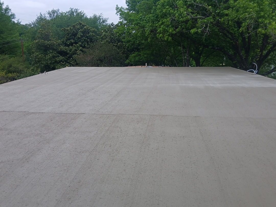 Broom-finished parking pad under the trees