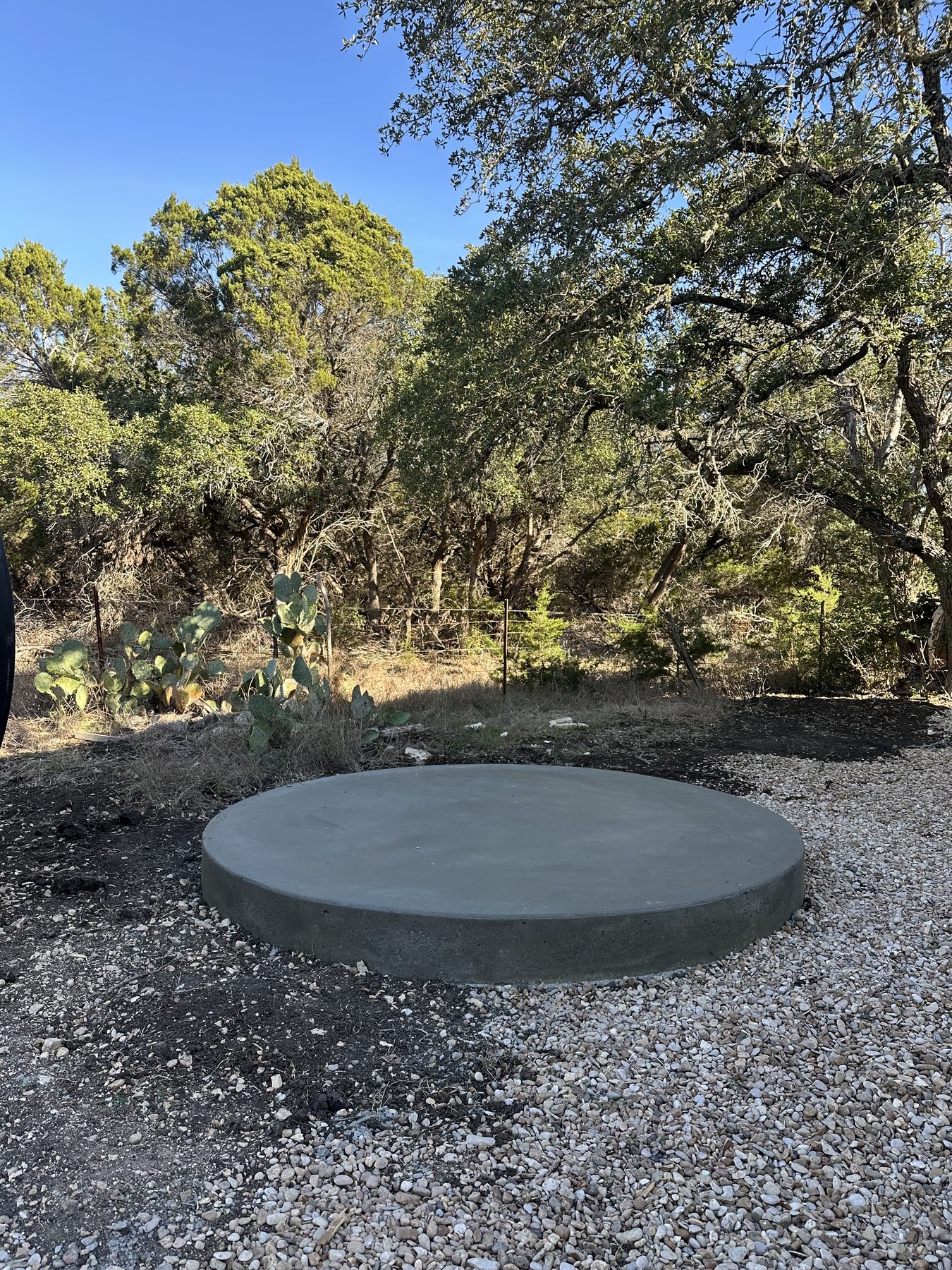 Round concrete pad poured in a gravel yard